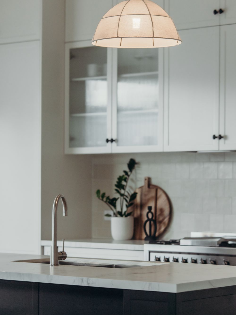 Light mineral surface benchtop and splashback over a black island in Mayfield