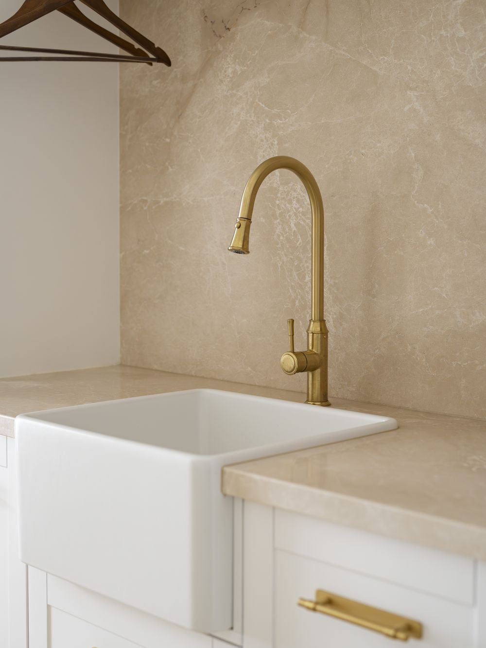 Laundry sink and stone splashback with a brass tap in Bolwarra